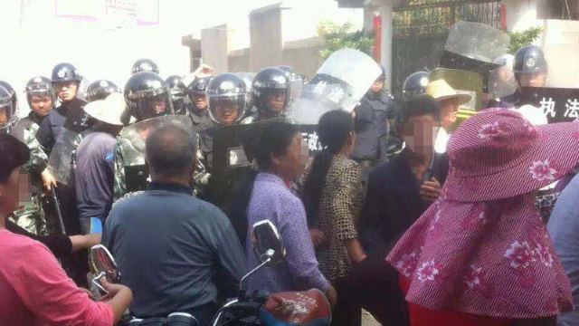 무장경찰들이 철거 반대 시위 중인 신도들을 가로막는 모습