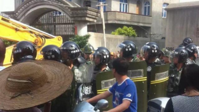 무장경찰들이 철거 반대 시위 중인 신도들을 가로막는 모습