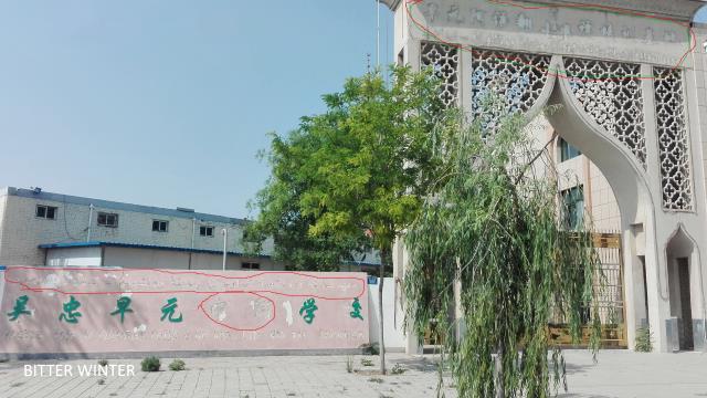 아랍어 문자와 이를 번역한 중국어, 영어 단어가 학교 지붕과 입구에서 모두 철거된 모습