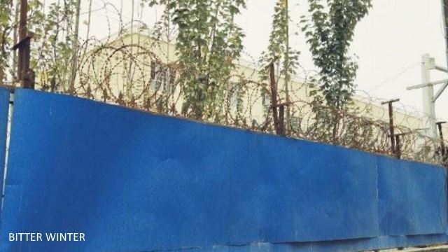 철조망과 푸른 강철판으로 둘러진 수용소 주변 담벽