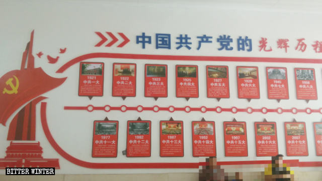 “공산당의 영광스러운 역사”라고 쓰여진 포스터가 차오우 마을 교회 벽에 게시되어 있다.