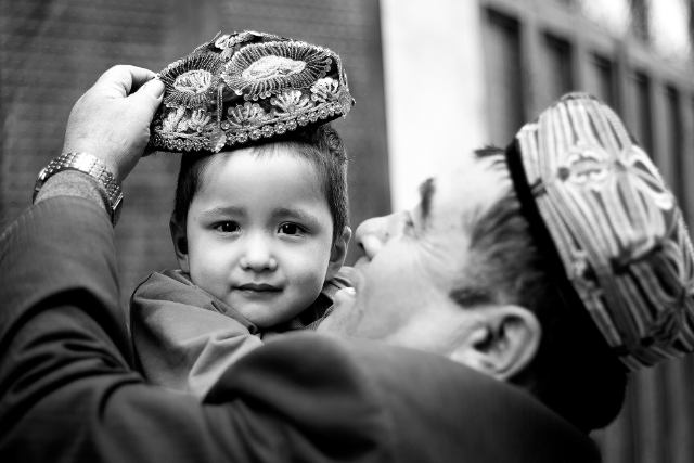 수를 놓은 도파(전통적인 모자)를 아들에게 씌워주는 남자. © Maxime Crozet
