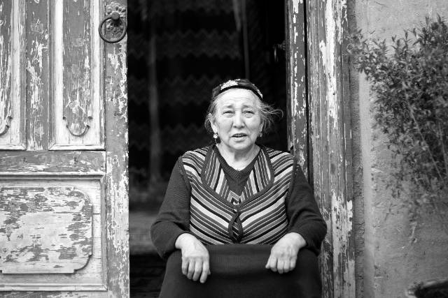 카슈가르에 있는 자기 집 문간에 선 위구르족 여성. © Maxime Crozet