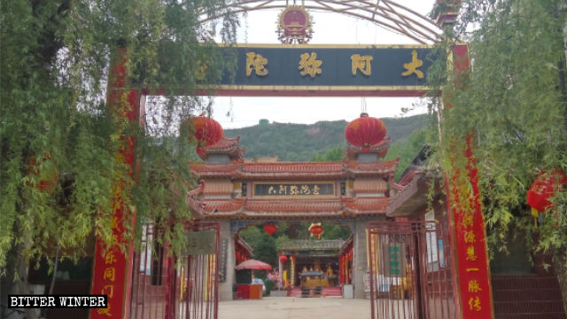 사원의 아치형 기념문 위에 있던 불교 상징물은 중국의 붉은 휘장(國章)으로 대체되었다.