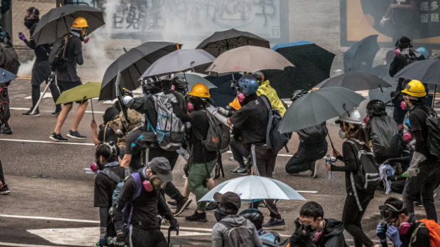 홍콩 시위대와 리포터들은 경찰의 최루탄 공격을 견디기 위한 안면 마스크와 우산이 필요하다