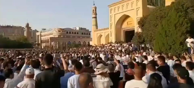 이드 카(Id Kah) 이슬람 사원 앞에서 중국 관광객들이 가짜 '성스러운 춤' 공연을 보는 모습