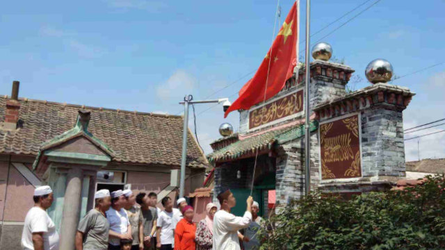 랴오닝성의 어느 모스크에서 무슬림들이 강제로 국기 게양식을 진행하고 있다.