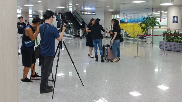 중국 본토에서 온 전능신교 신자의 가족들을 공항에서 맞은 오명옥 씨가 언론에 공개할 사진을 찍으려고 준비하는 모습