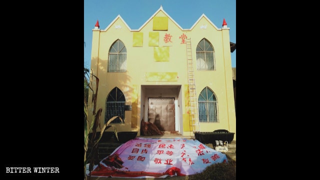 정춘(正村)진의 어느 삼자교회 외벽에 있던 종교 상징들이 현재 합판으로 가려진 모습