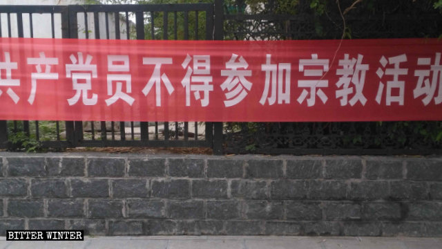 허난(河南)성 후이셴(辉县)시 상바리(上八里)진의 거리에 걸려 있는 당원들의 종교 활동을 금한다는 내용의 현수막