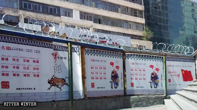 철조망으로 둘러싸인 벽에 시진핑 주석의 중국몽을 선전하는 포스터가 붙어 있다