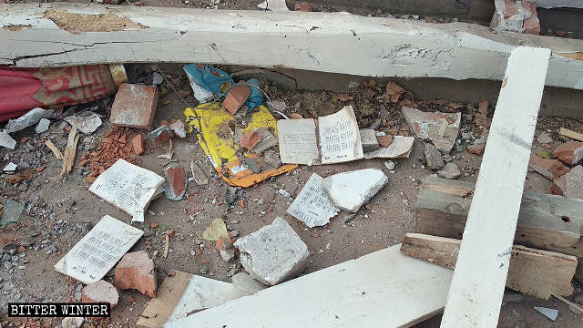 철거된 교회의 잔해 속에 흩어져 있는 찬송가집
